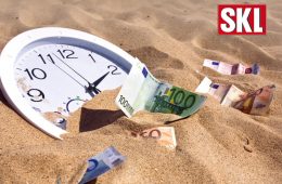Uhr und Geldscheine im Sand