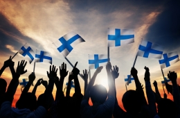 Menschen strecken finnische Flaggen in die Höhe.