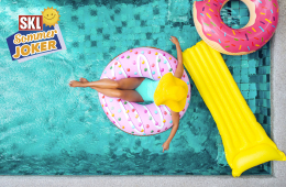 Frau mit gelbem Sonnenhut im Pool auf einem Donut-Schwimmreifen