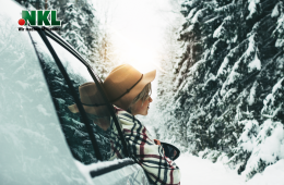 Schöne FRau fährt im Winter mit dem Auto durch Schnee.
